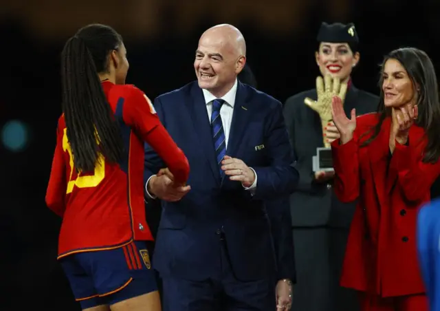 Fifa president shaking hands with midfielder Salma Paralluelo