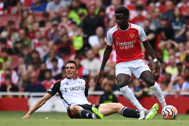 Joao Palhinha of Fulham and Bukayo Saka of Arsenal challenge during the Premier League match between Arsenal and Fulham at Emirates Stadium on August 26, 2023