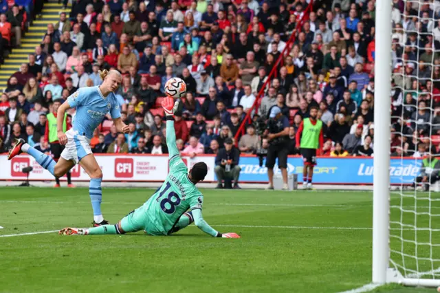 Foderingham lifts a big hand to deny a lofted shot from Haaland.