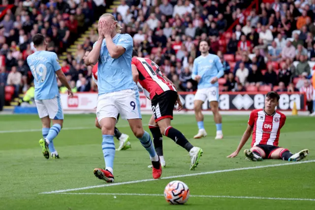 Haaland holds his hands to his face in irritation.