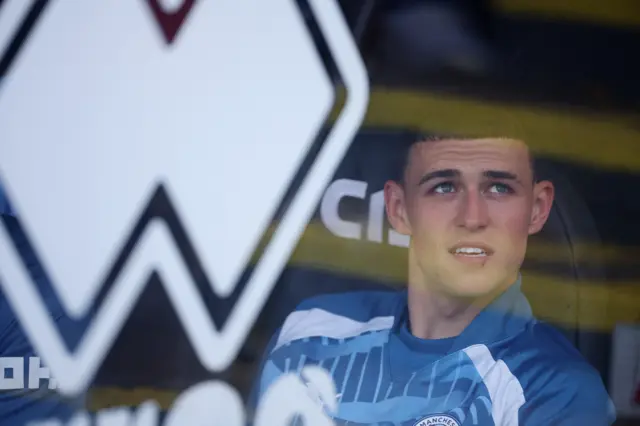 Phil Foden sits on the bench at Bramhall Lane.