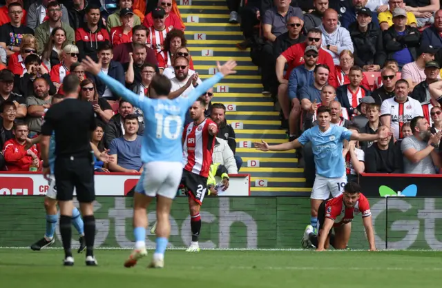 City players wave and shout for a penalty as Egan looks at the referee nervously.