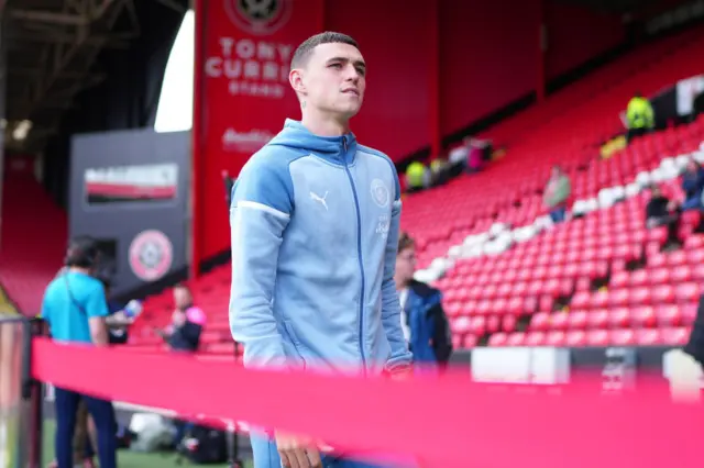 Phil Foden arrives at Bramhall Lane, walking in front of the main stand.