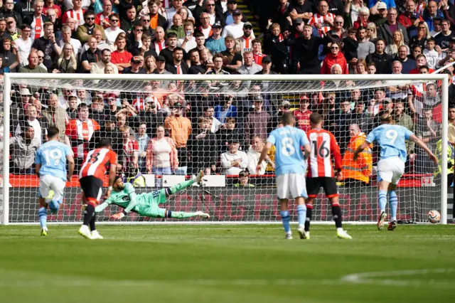 Haaland's spot kick head towards the post as the keeper dives the wrong way.