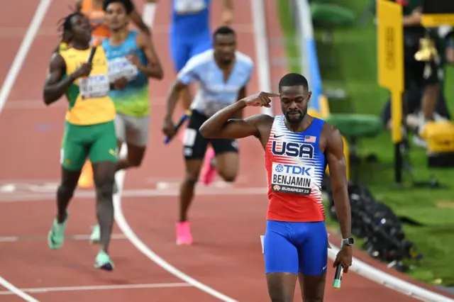 Rai Benjamin points to his head in celebration after winning the 4x400m relay final