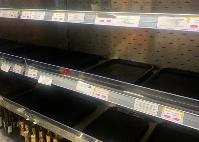 An image of empty supermarket shelves