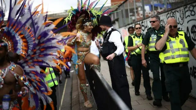 A police officer speaks to a costumed performer