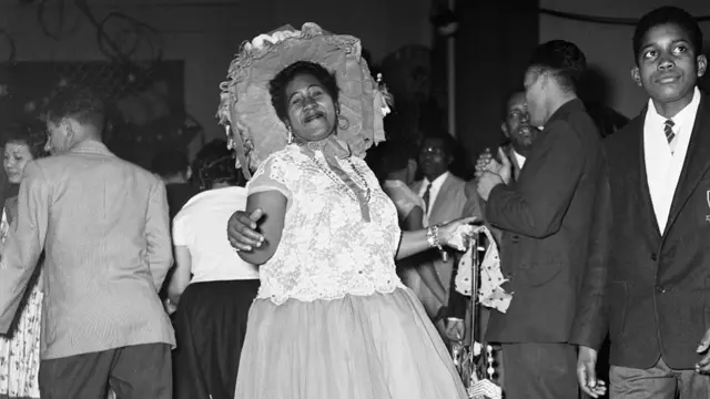 A black and white photo of a woman smiling as she dances