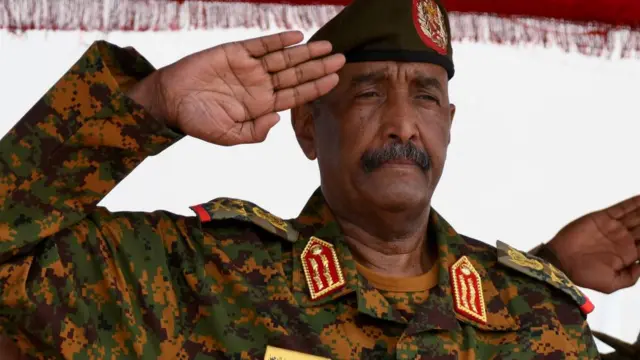 Sudan's General Abdel Fattah al-Burhan salutes as he listens to the national anthem after landing in the military airport of Port Sudan on his first trip away following the crisis in Sudan's capital Khartoum since an internal conflict broke out, in the city of Port Sudan, Sudan, August 27, 2023