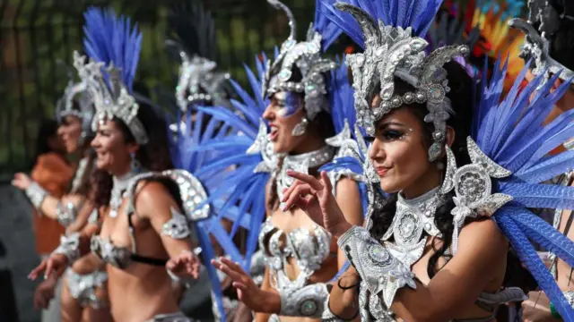 A row of dancers in silver costumes