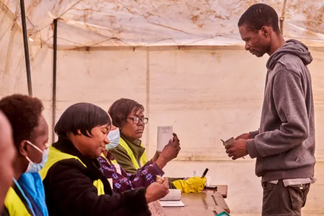 A voter arrives at a polling station to cast his ballot as the election extends to a second day after long ballot delays, on August 24, 2023 in Harare, Zimbabwe.