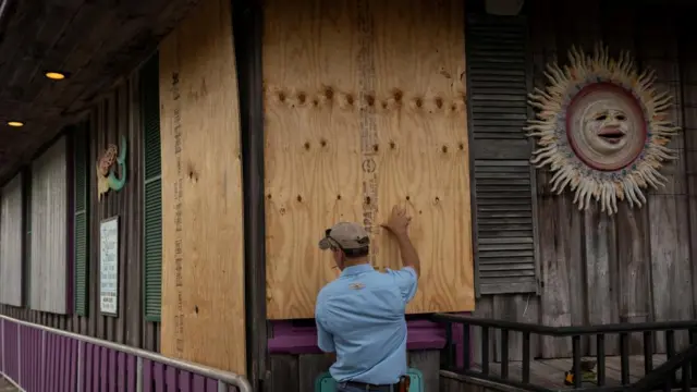 A man places plywood barricades ahead of the hurricane's arrival in Cedar Key