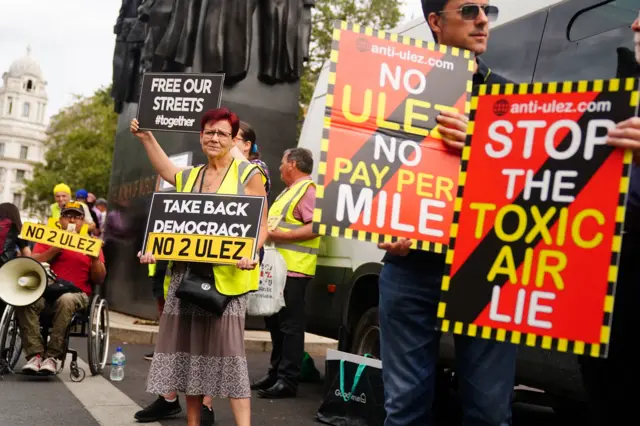 Anti-Ulez protests outside Downing Street, with signs saying things like "no 2 Ulez" and "no Ulez, no pay per mile"