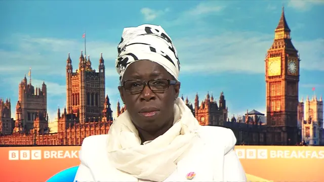 Rosamund Adoo-Kissi-Debrah sitting in front of a BBC Breakfast branded backdrop