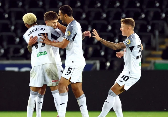 Swansea's Jamie Paterson celebrates scoring their second goal with Azeem Abdulai, Ben Cabango and Harrison Ashby