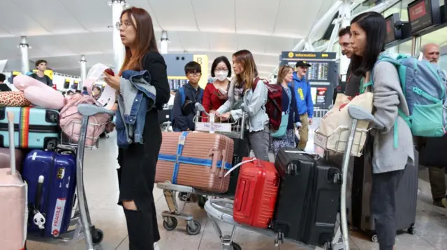 Passengers wait in a departure lounge at Heathrow Airport