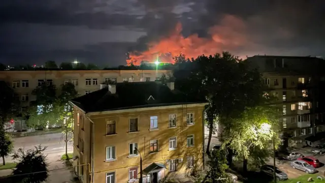 A handout photo made available by the Governor of Russian Pskov region Mikhail Vedernikov Telegram channel shows smoke billowing and explosions light