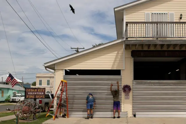 Volunteers place hurricane shutters at the Cedar Key Fire Station ahead of the arrival of Hurricane Idalia, in Cedar Key, Florida, U.S., August 29, 2023.