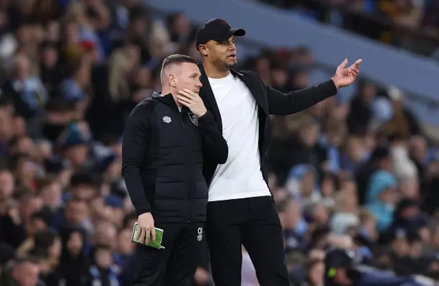 Craig Bellamy and Vincent Kompany on the touchline look on