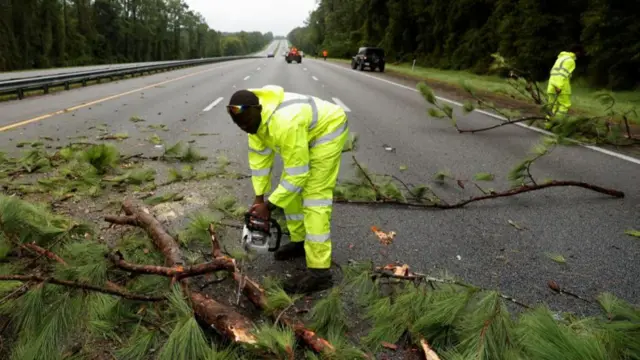 Workers clean up a blockade at Interstate 75 (I-75) highway after the arrival of Hurricane Idalia, near Gainesville, Florida