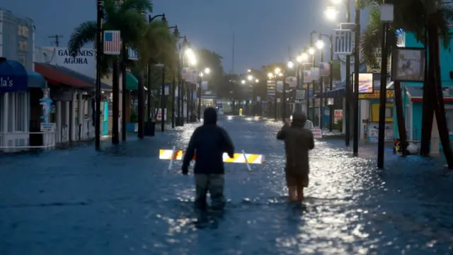 Reporters on flooded street