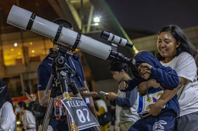 Boy looking through giant telescpe in Jakarta