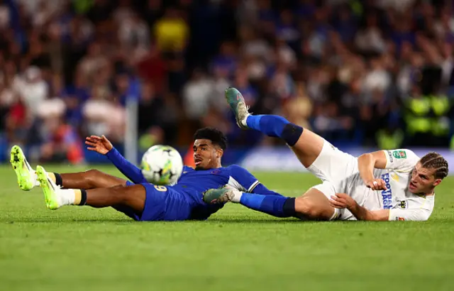 Josh Davison of AFC Wimbledon clashes with Ian Maatsen of Chelsea