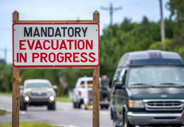 Vehicles move nex to a 'mandatory evacuation' sign, as the town prepares for Hurricane Idalia, in Cedar Key, Florida, USA, 29 August 2023. Hurricane Idalia is forecast to make landfall in northwest Florida on 30 August as a Category 3 major hurricane.