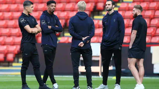 Lincoln City players looking at Bramall Lane before their football match with Sheffield United