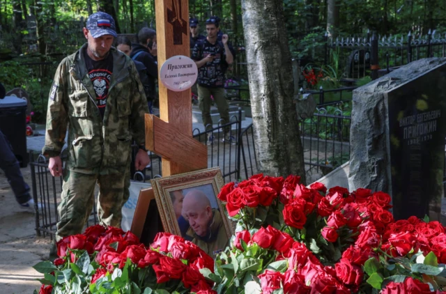 A Wagner soldier stands by the grave of Yevgeny Prigozhin in St Petersburg