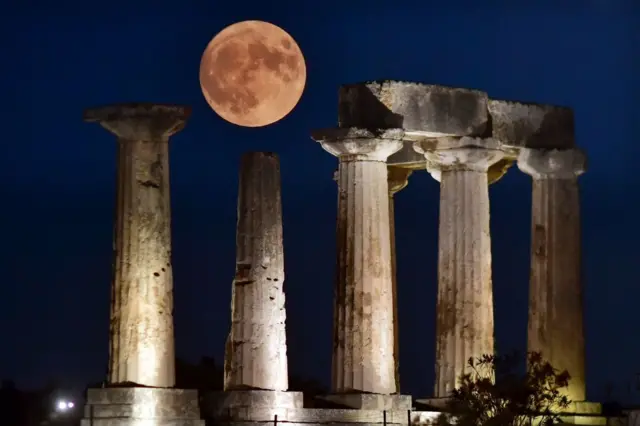 The "Blue Supermoon", the second full moon of a calendar month, rises above the Apollo Temple in ancient Corinth, on August 30, 2023.