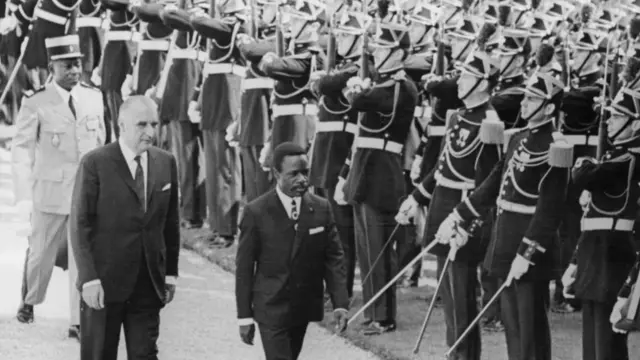 Omar Bongo (1935 - 2009), the President of Gabon, inspects a guard of honour of the French Republican Guard with French President Georges Pompidou (1911 - 1974, left), after arriving in Paris, France, 6th July 1970