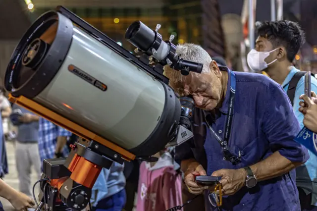 Astronomer watches at the full moon known as the ''Blue Moon'' through an astronomical telescope as it rises over Taman Ismail Marzuki, in Jakarta, Indonesia on August 30, 2023.