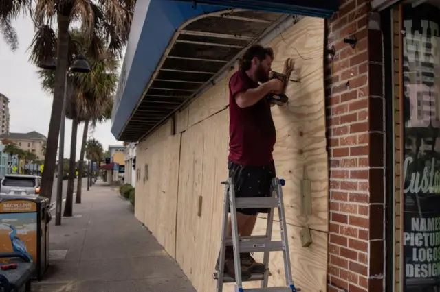 A man boarding up a shop ahead of the arrival of Hurricane Idalia in Clearwater Beach, Florida, U.S., August 29, 2023.