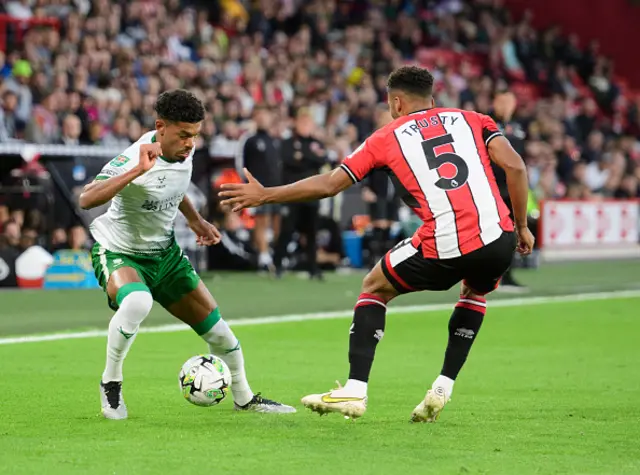 Lincoln City's Reeco Hackett vies for possession with Sheffield United's Auston Trusty