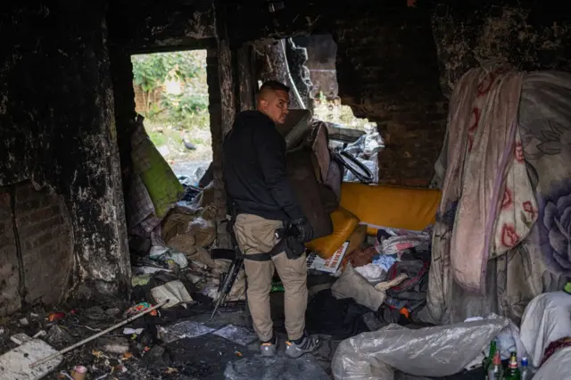 plainclothes police officer with the Johannesburg Metro Police Department (JMPD) inspects a dilapidated building used as shelter in Johannesburg on May 15, 2023