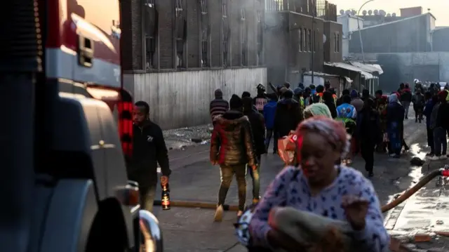 People walk past blaze site in Johannesburg