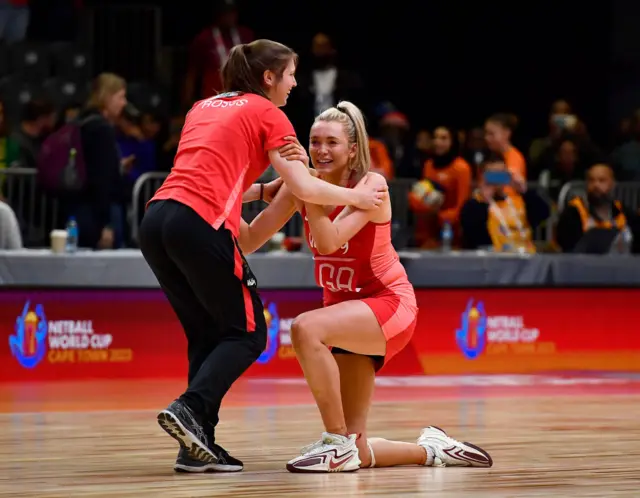 Housby is helped to her feet after by a coach.