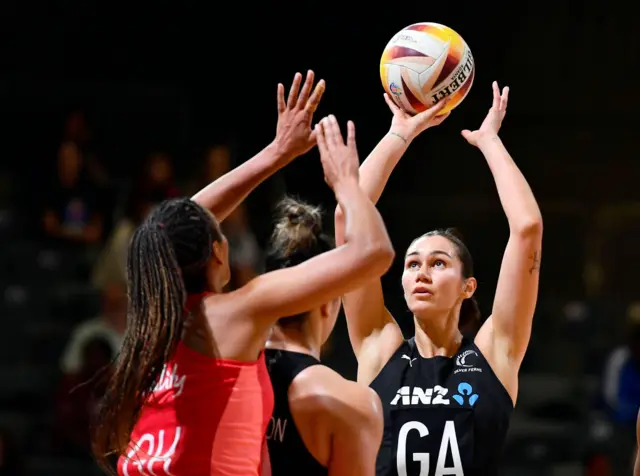 Ekenasio shoots under pressure from England defenders.