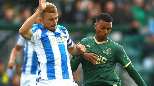 Plymouth Argyle and Huddersfield players go for the ball