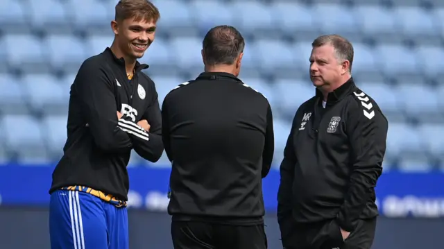 Callum Doyle of Leicester City talks to Coventry boss Mark Robins