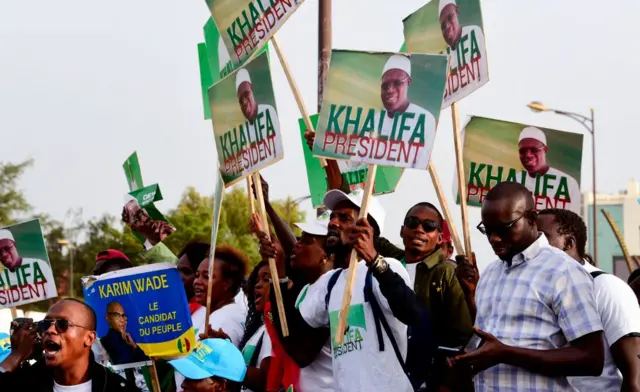 Senegal's opposition demonstrators hold pictures of former minister Karim Wade and of the Mayor of Dakar Khalifa Sall during a march to demand transparency in next year's elections, in Dakar, on November 29, 2018.