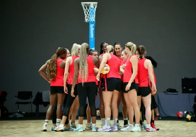 England players huddle together on court after practice.