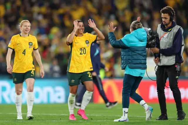 Sam Kerr high fives teammates at full time.