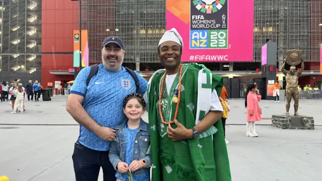 England fans Andy and Tilly take a photo with Nigeria fan Fred.