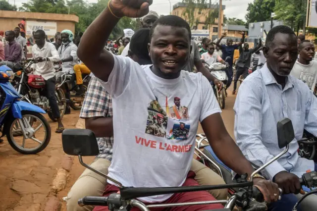 A protester wearing a t-shirt in support of the Niger, Mali, Guinea and Burkina Faso junta leaders gesture during a demonstration on independence day in Niamey on August 3, 2023.