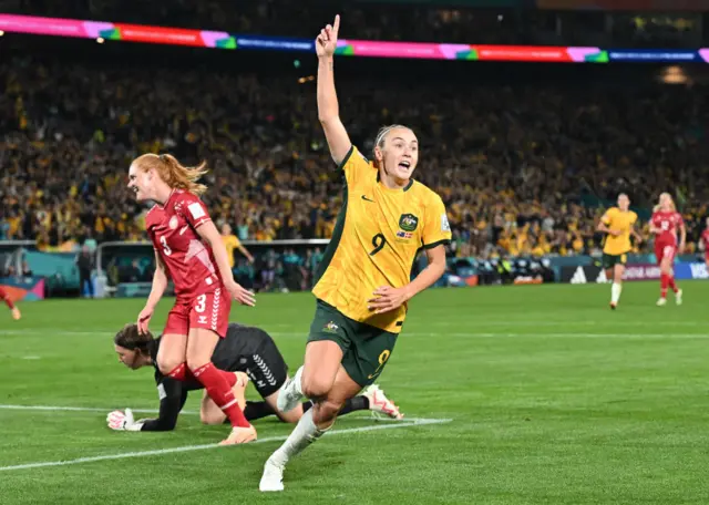 Caitlin Foord celebrates with her hand in the air after opening the scoring.