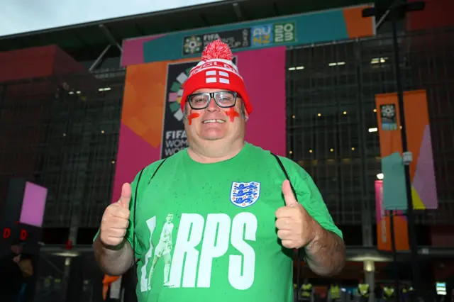 AN England fan holds his thumbs up while donning a shirt in support of Mary Earps,.