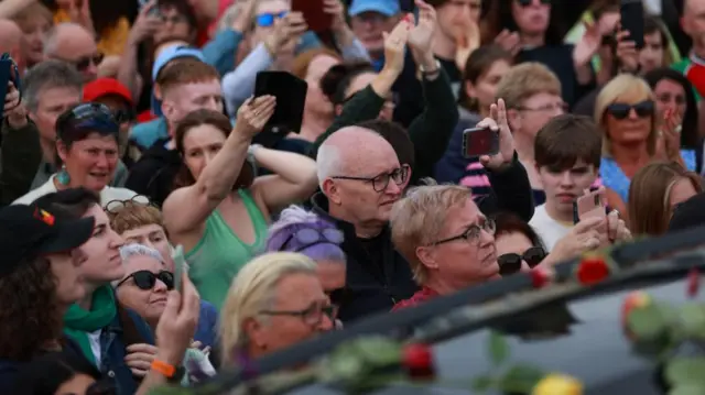 fans wave to the car