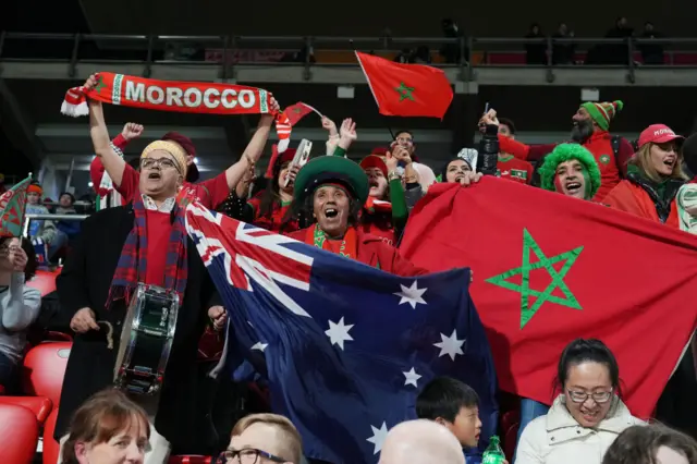 The Morocco fans stand ready with flags and banners to support their side.